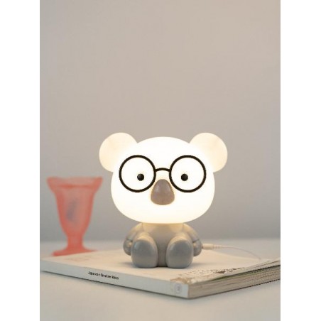 Lampada Koala accesa su libro, ambientazione elegante