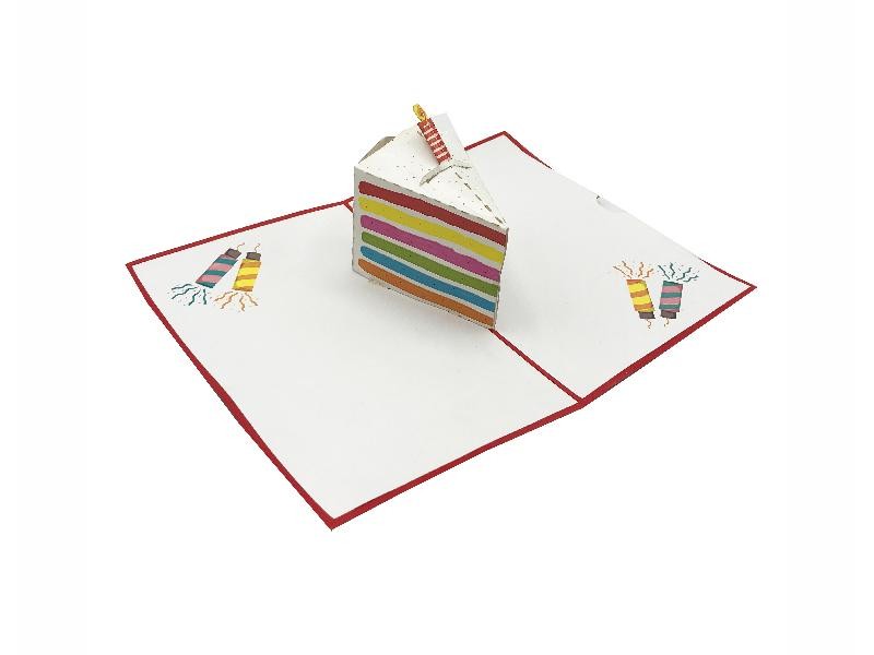 Biglietto di compleanno con fetta di torta pop-up arcobaleno su sfondo bianco