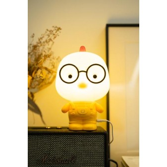 Lampada Pulcino accesa su amplificatore, con sfondo decorativo e atmosfera serale