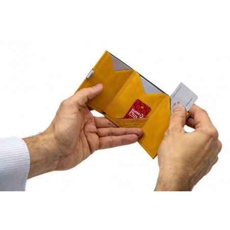 Portafoglio Exentri giallo aperto e tenuto in mano, mostrando la praticità d'uso e la capacità di organizzazione.