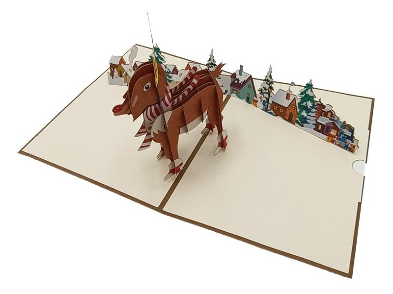 Biglietto pop-up 3D renna con villaggio innevato natalizio